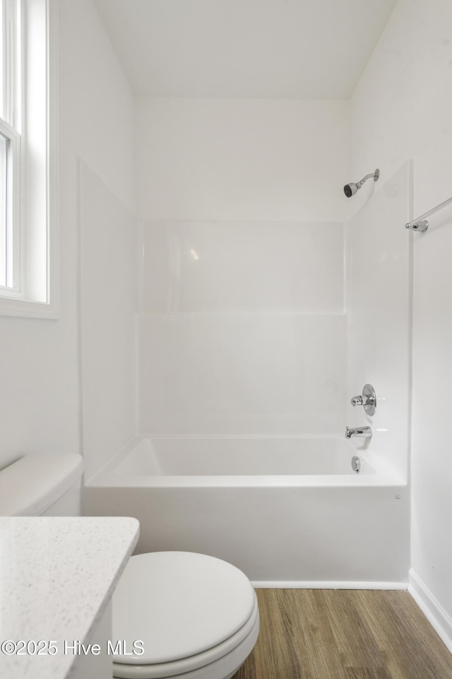 full bathroom featuring toilet, wood finished floors, vanity, and shower / tub combination