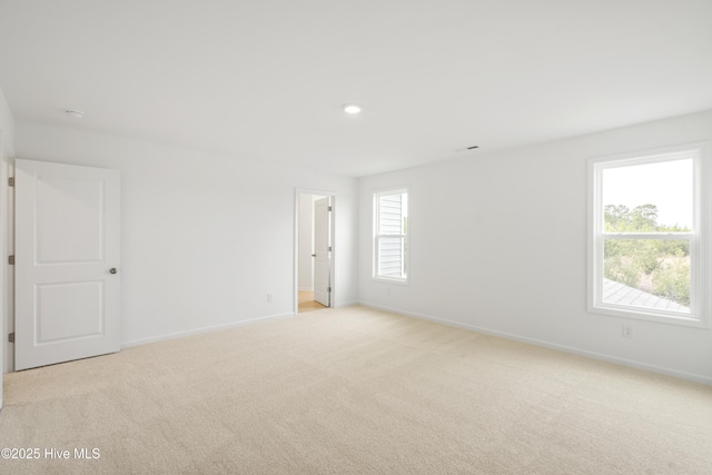 unfurnished room with recessed lighting, baseboards, and light carpet