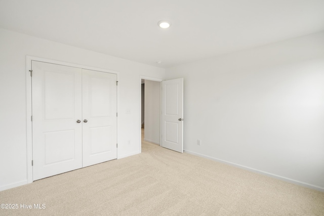 unfurnished bedroom featuring carpet, baseboards, and a closet