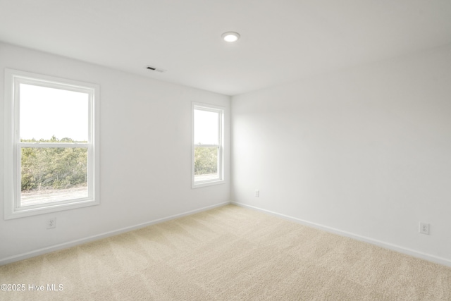 carpeted empty room with baseboards and visible vents