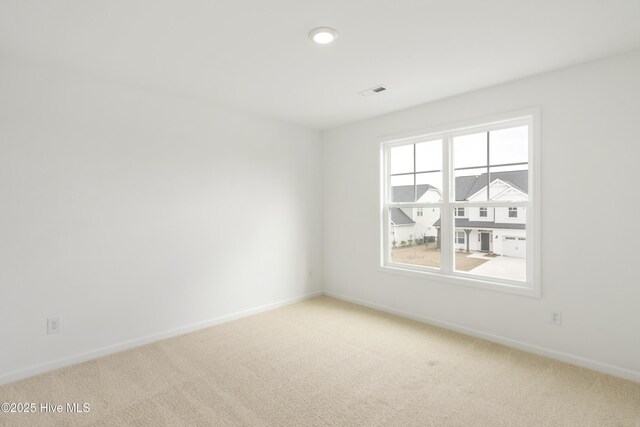 carpeted empty room featuring visible vents and baseboards