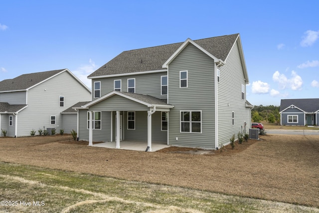 back of house featuring cooling unit, a patio, and a shingled roof