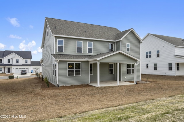 back of property with a patio and a shingled roof