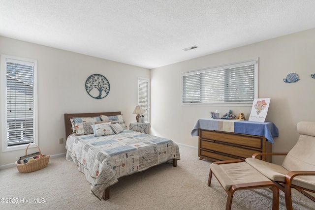 carpeted bedroom featuring baseboards, visible vents, and a textured ceiling