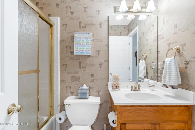 full bathroom with wallpapered walls, toilet, and vanity