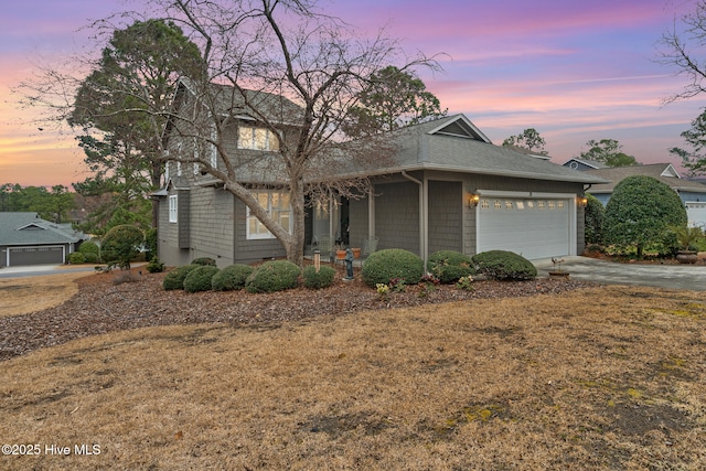 view of front of property with concrete driveway, a garage, and roof with shingles