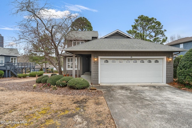 view of front facade with roof with shingles, concrete driveway, and an attached garage