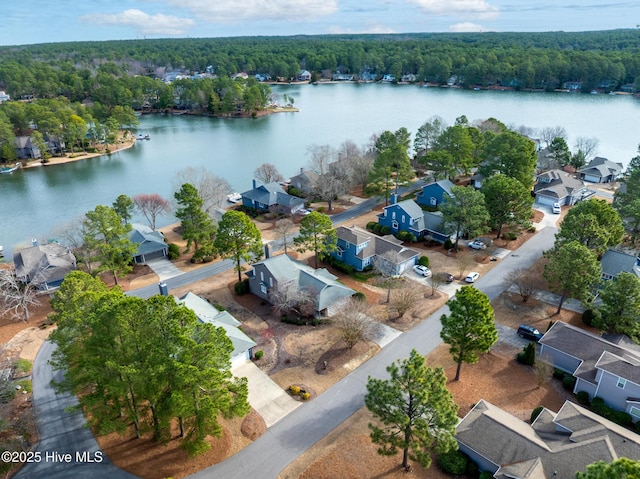 birds eye view of property with a residential view, a wooded view, and a water view