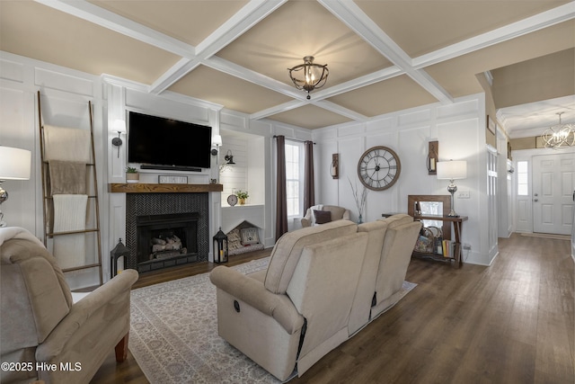 living area with a notable chandelier, plenty of natural light, coffered ceiling, and dark wood finished floors