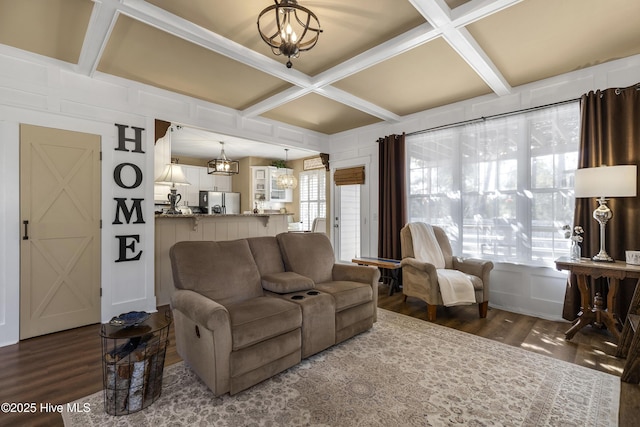 living room with a notable chandelier, coffered ceiling, and wood finished floors