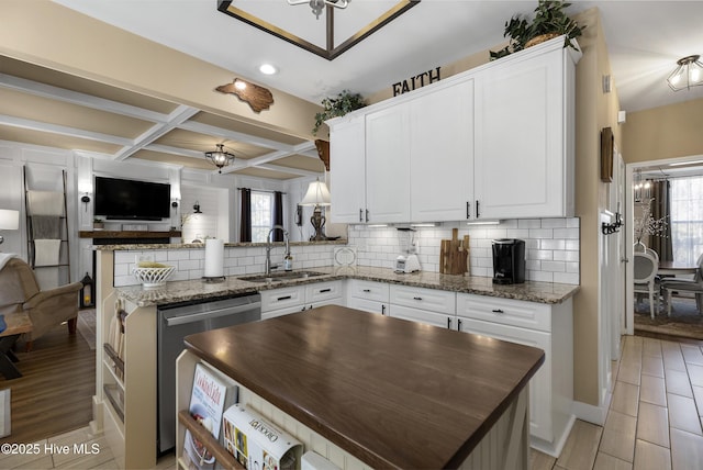 kitchen with coffered ceiling, a peninsula, a sink, dishwasher, and tasteful backsplash