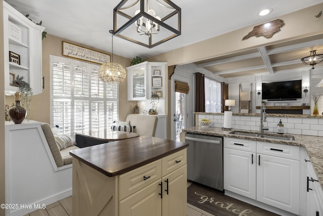 kitchen featuring a notable chandelier, a sink, tasteful backsplash, stainless steel dishwasher, and coffered ceiling