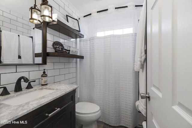 full bathroom with vanity, a shower with shower curtain, decorative backsplash, tile walls, and toilet