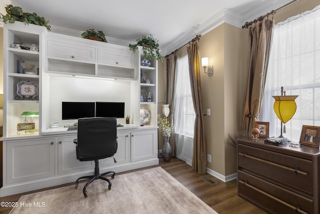 office area featuring visible vents, ornamental molding, wood finished floors, built in desk, and baseboards