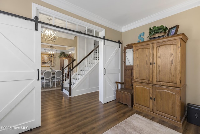 foyer with dark wood-style floors, an inviting chandelier, crown molding, and a barn door