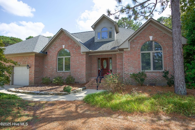 traditional-style house with an attached garage, brick siding, roof with shingles, and crawl space