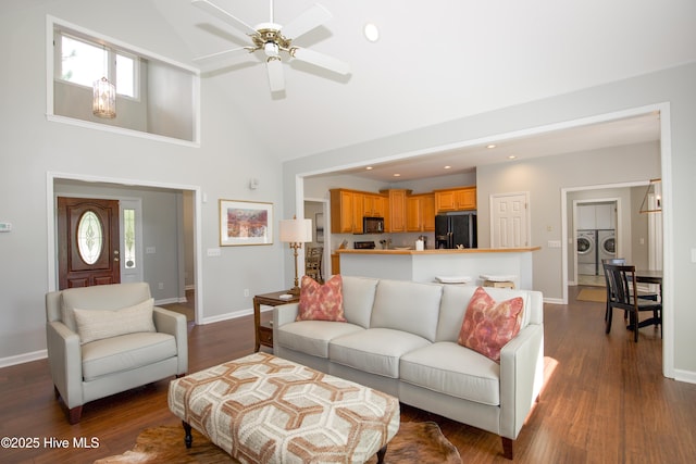 living room featuring a wealth of natural light, baseboards, and dark wood-type flooring