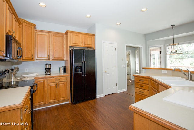 kitchen featuring light countertops, recessed lighting, dark wood-style floors, black appliances, and a sink