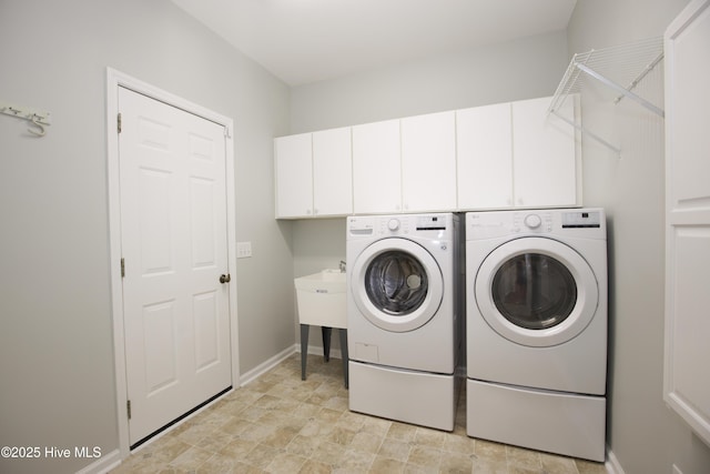 washroom featuring baseboards, cabinet space, and independent washer and dryer