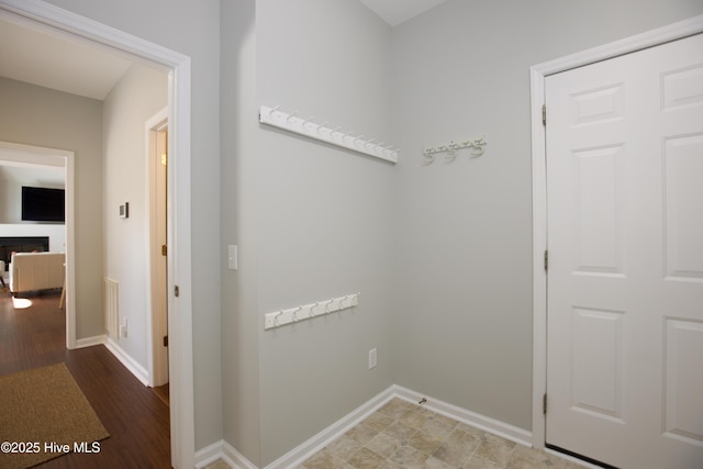 hall featuring wood finished floors and baseboards