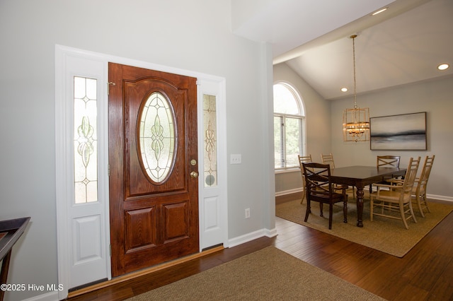 foyer with dark wood-type flooring, baseboards, lofted ceiling, recessed lighting, and an inviting chandelier