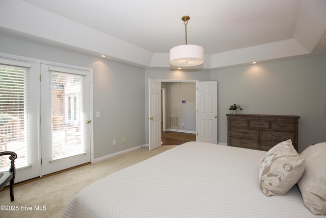 bedroom featuring visible vents, light carpet, a raised ceiling, access to outside, and baseboards