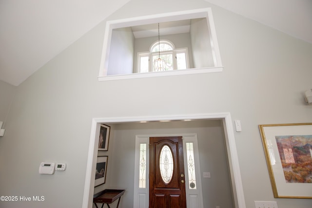 foyer entrance featuring high vaulted ceiling and an inviting chandelier