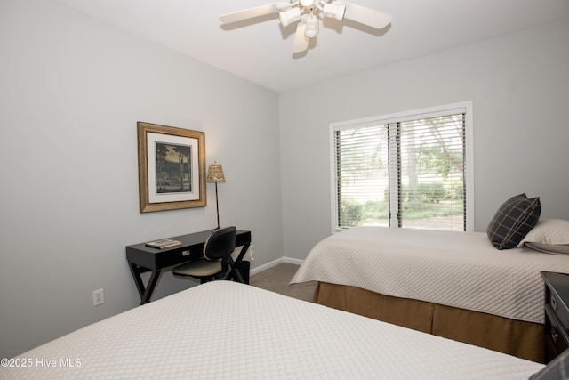 bedroom featuring baseboards, dark carpet, and ceiling fan