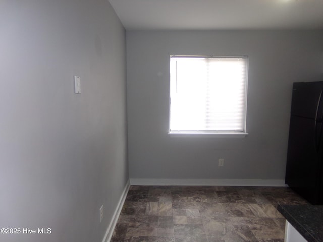 unfurnished room with baseboards