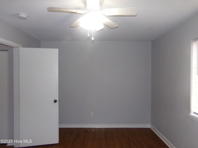 unfurnished room with a ceiling fan, wood finished floors, and baseboards