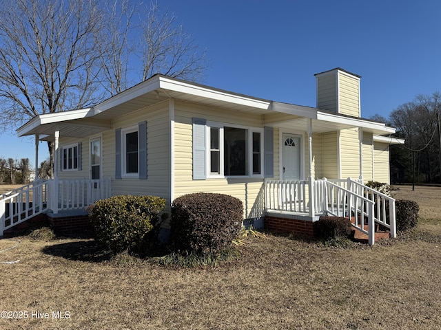 view of front of home with covered porch and a chimney