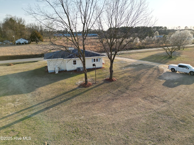 view of front of house with cooling unit, driveway, and a front yard