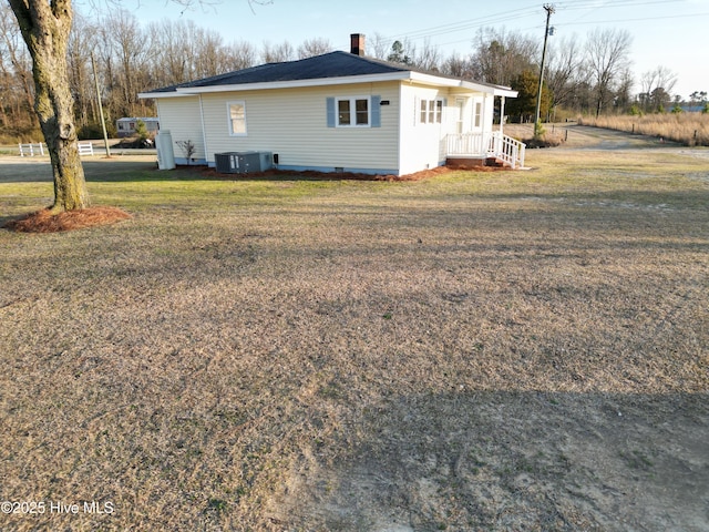 view of home's exterior featuring crawl space, a yard, cooling unit, and a chimney