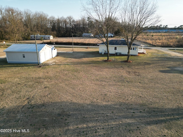 view of yard with an outbuilding, a rural view, and an outdoor structure