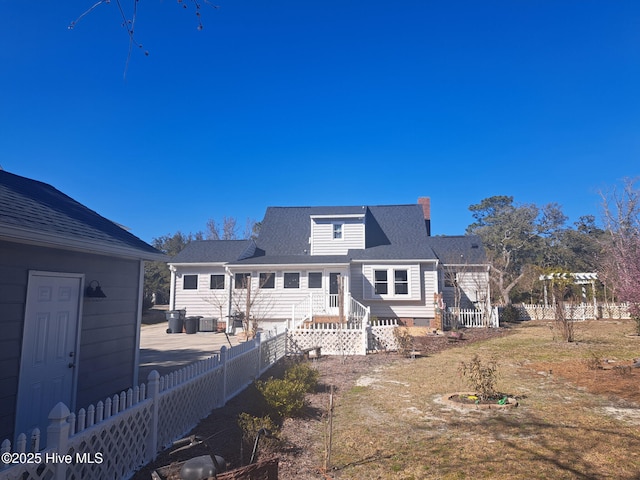 back of house with fence and central AC