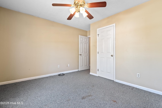 carpeted empty room with a ceiling fan and baseboards