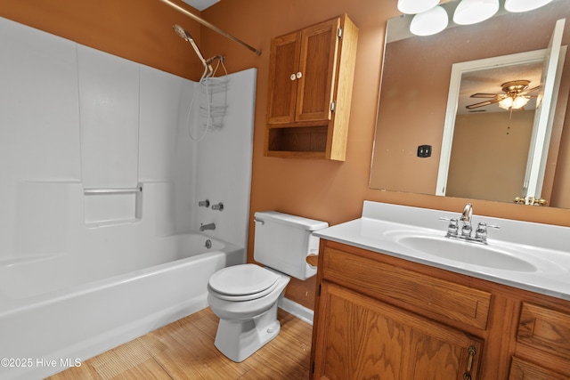 bathroom featuring ceiling fan, toilet, vanity, and  shower combination