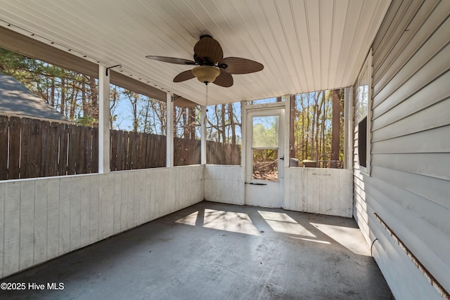 unfurnished sunroom featuring a ceiling fan