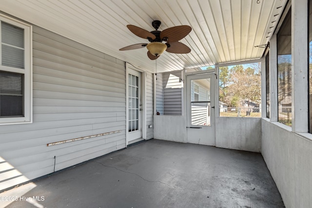 unfurnished sunroom with ceiling fan