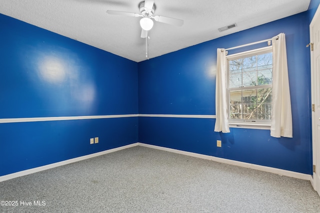 carpeted empty room with visible vents, a textured ceiling, baseboards, and a ceiling fan