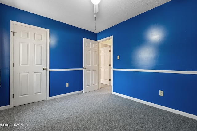 carpeted spare room with ceiling fan, a textured ceiling, and baseboards