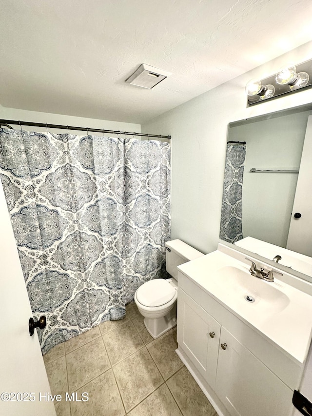 bathroom featuring visible vents, toilet, a textured ceiling, tile patterned flooring, and vanity