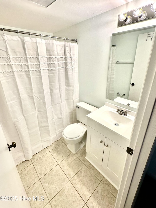 bathroom featuring tile patterned flooring, toilet, and vanity