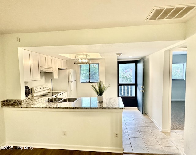 kitchen featuring visible vents, light stone countertops, a peninsula, white appliances, and white cabinetry