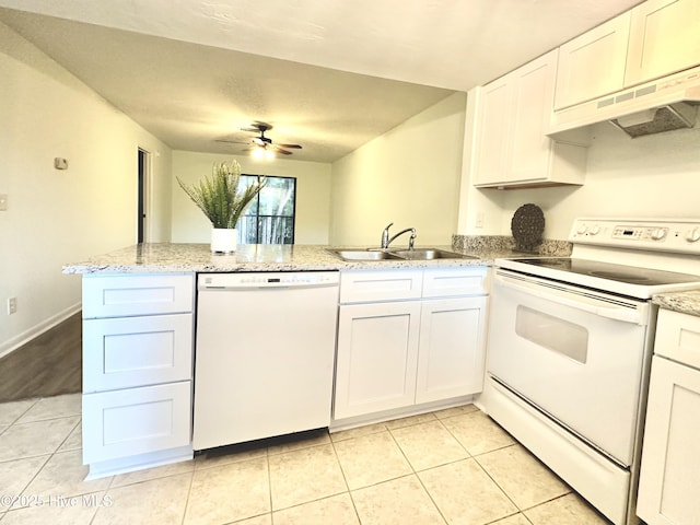 kitchen featuring under cabinet range hood, light tile patterned floors, a peninsula, white appliances, and a sink