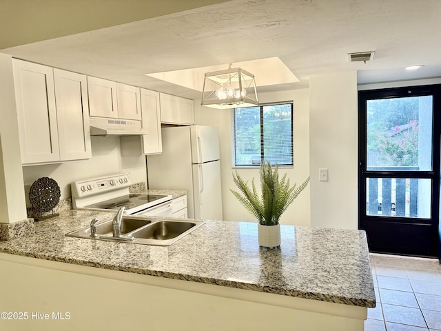 kitchen with visible vents, under cabinet range hood, a peninsula, white appliances, and white cabinetry