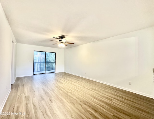 spare room with baseboards, ceiling fan, and wood finished floors