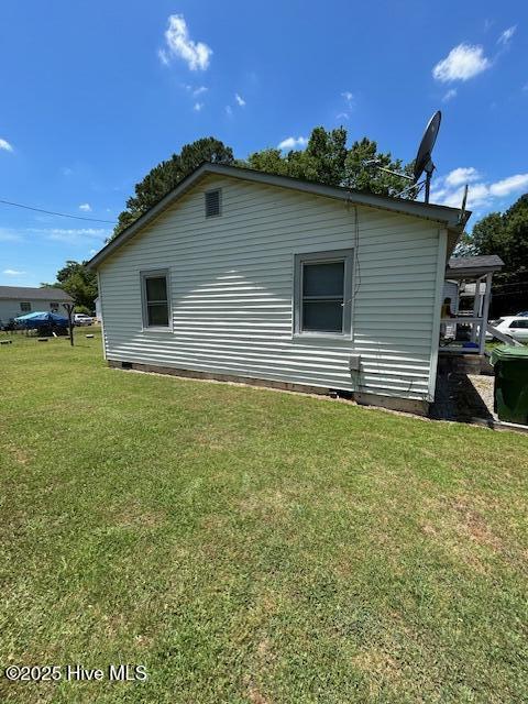 view of side of home with a yard