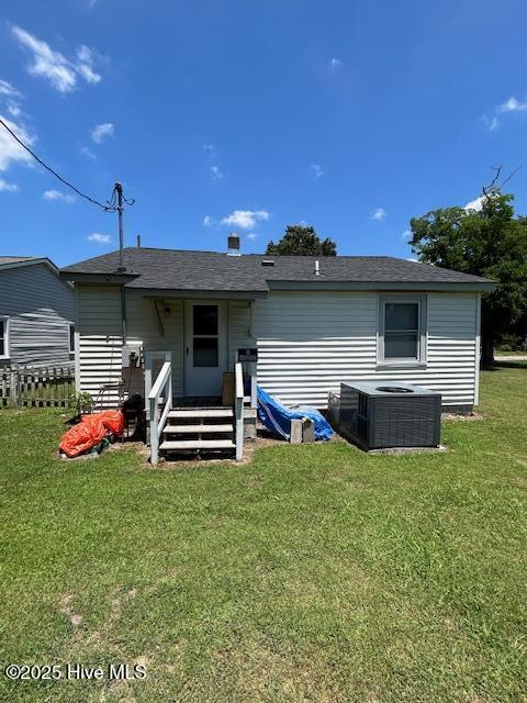 back of house with a yard and central AC