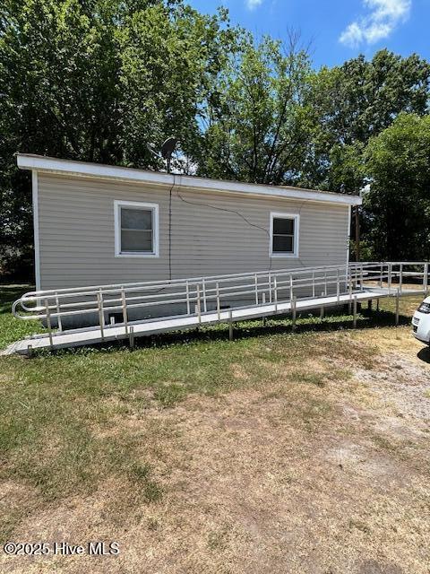 rear view of property featuring a yard and fence